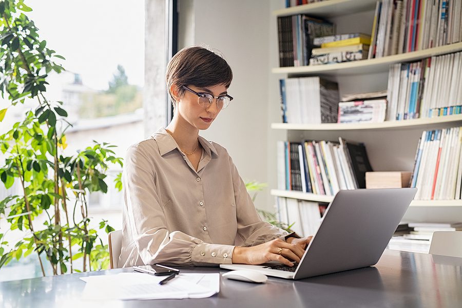 Business woman working on a lap top in her office.