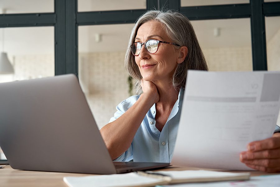 Smiling middle aged woman working on a computer at her desk.