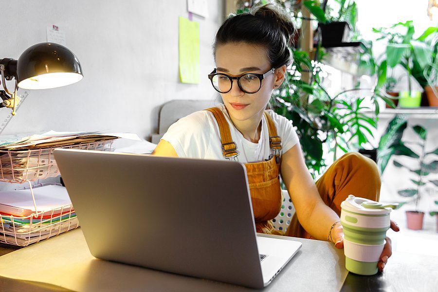 Young woman sitting at a desk with her laptop working from home.