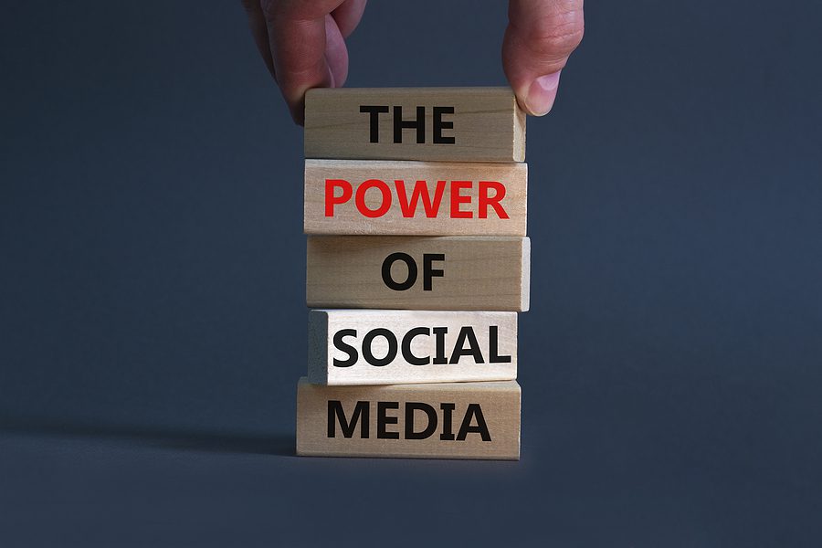 Power of social media symbol. Wooden blocks with words The power of social media. Businessman hand. Beautiful grey background, copy space. Business, power of social media concept.