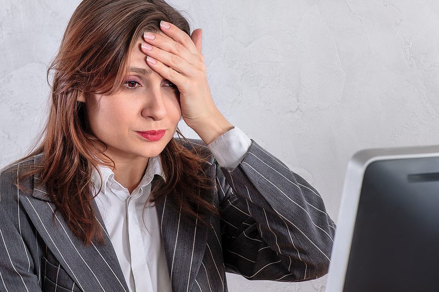 Business woman upset looking at her computer.