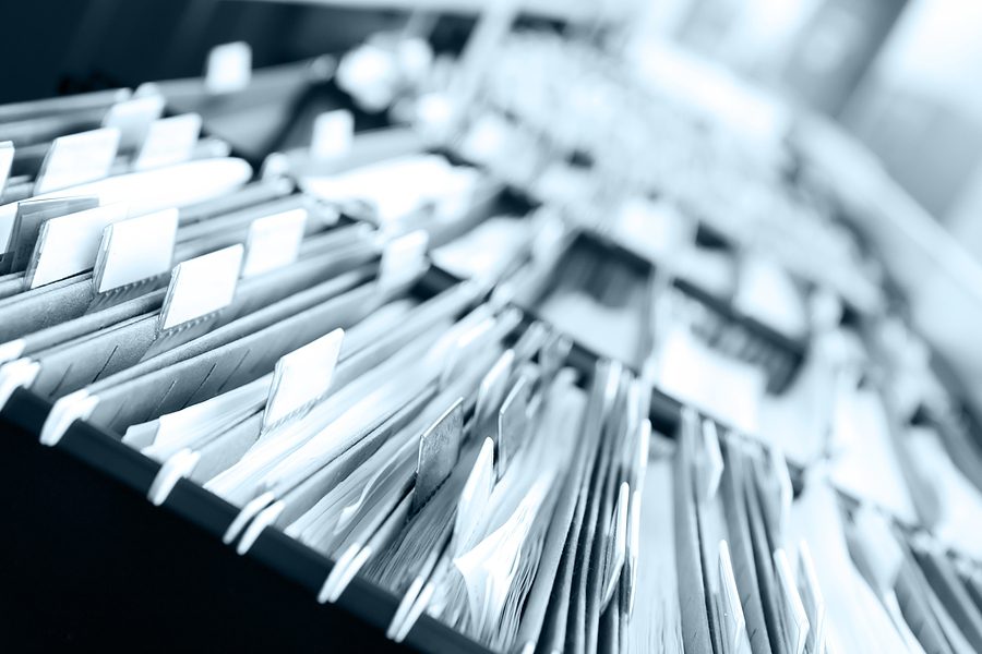 Close up photo of multiple full and open filing cabinet drawers