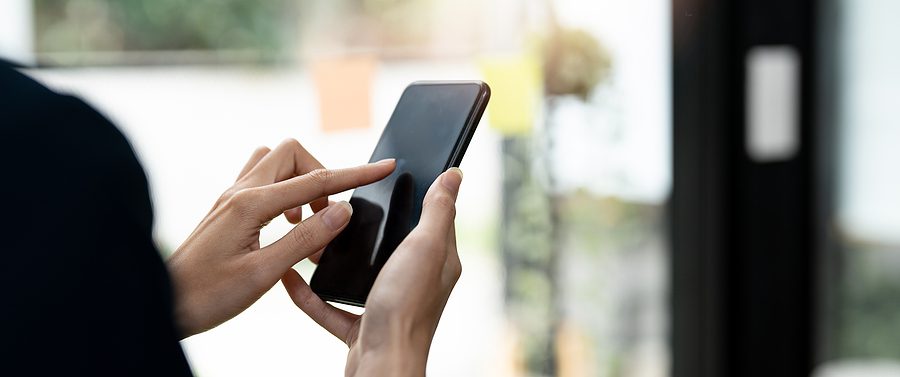 person's hands holding a smartphone about to tap on the screen