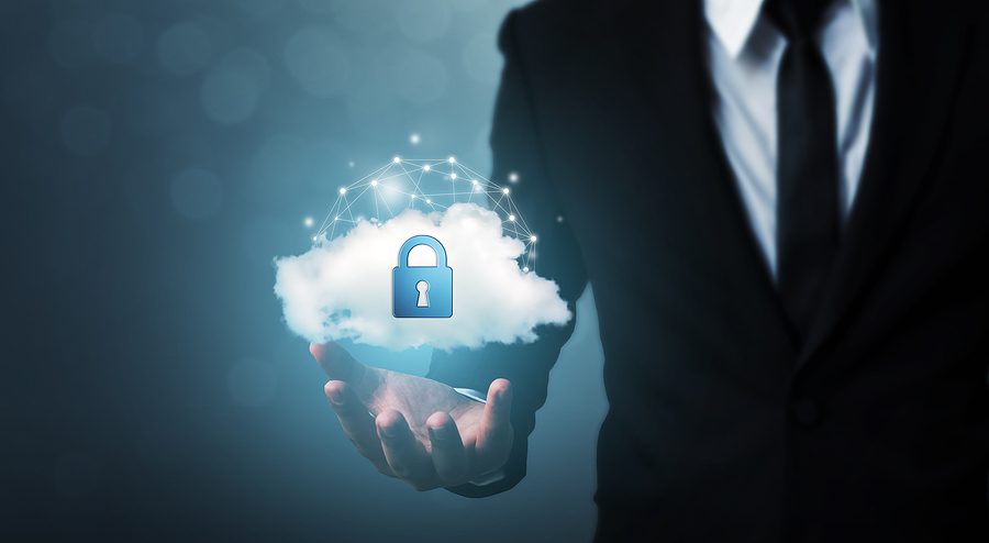 Closeup of a businessman in a suit holding a cloud with a lock on it to demonstrate the concept of corporate cloud security. 