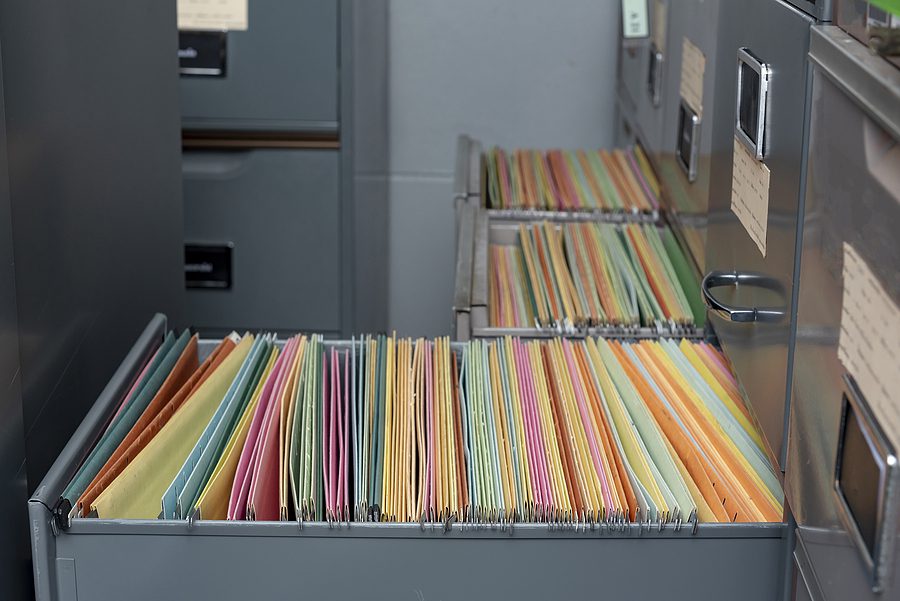 Open file cabinet drawer with old files. 