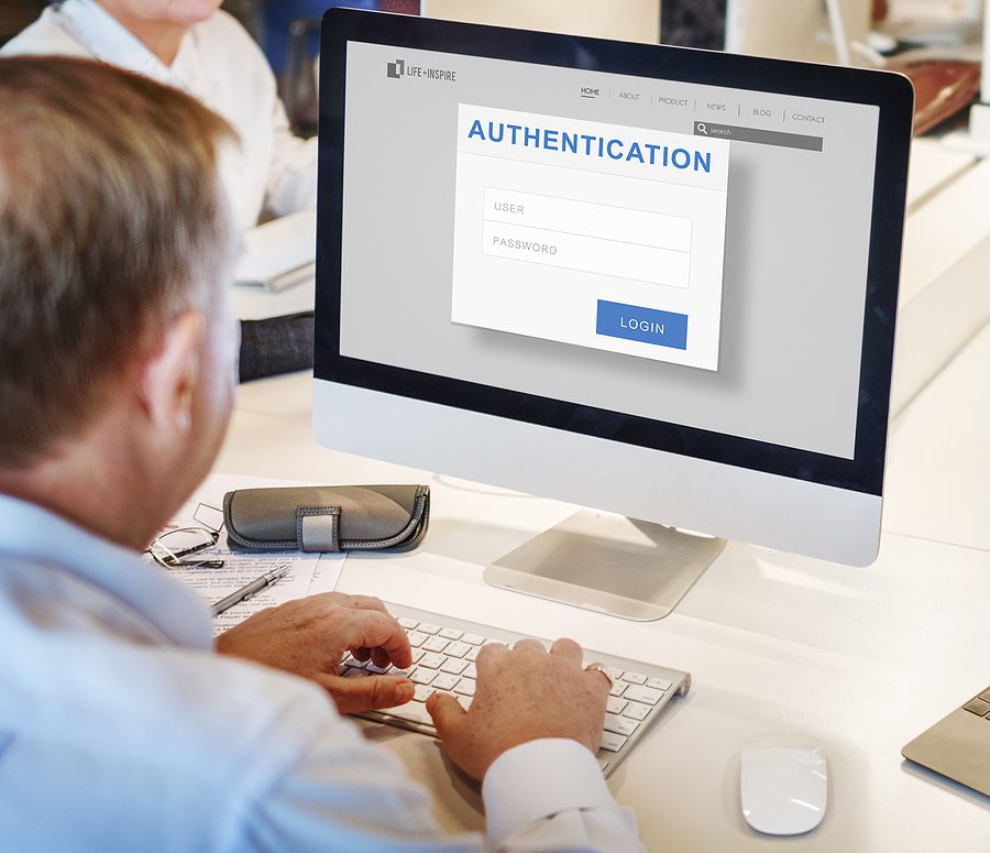 Office employee sitting at his computer, getting ready to enter in password authentication info.
