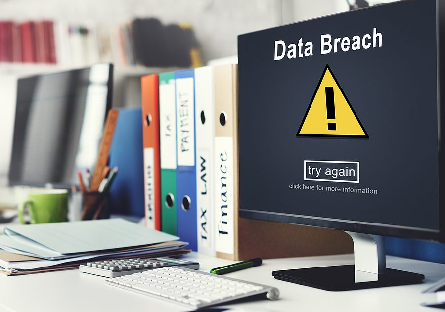 Computer screen sitting on an office desk with "Data Breach" warning on the screen. 